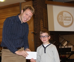 Jude Saunderson-Browne, 8, of Potter's House, hands a cheque to Mr Peter Hilton of the Leprosy Mission.